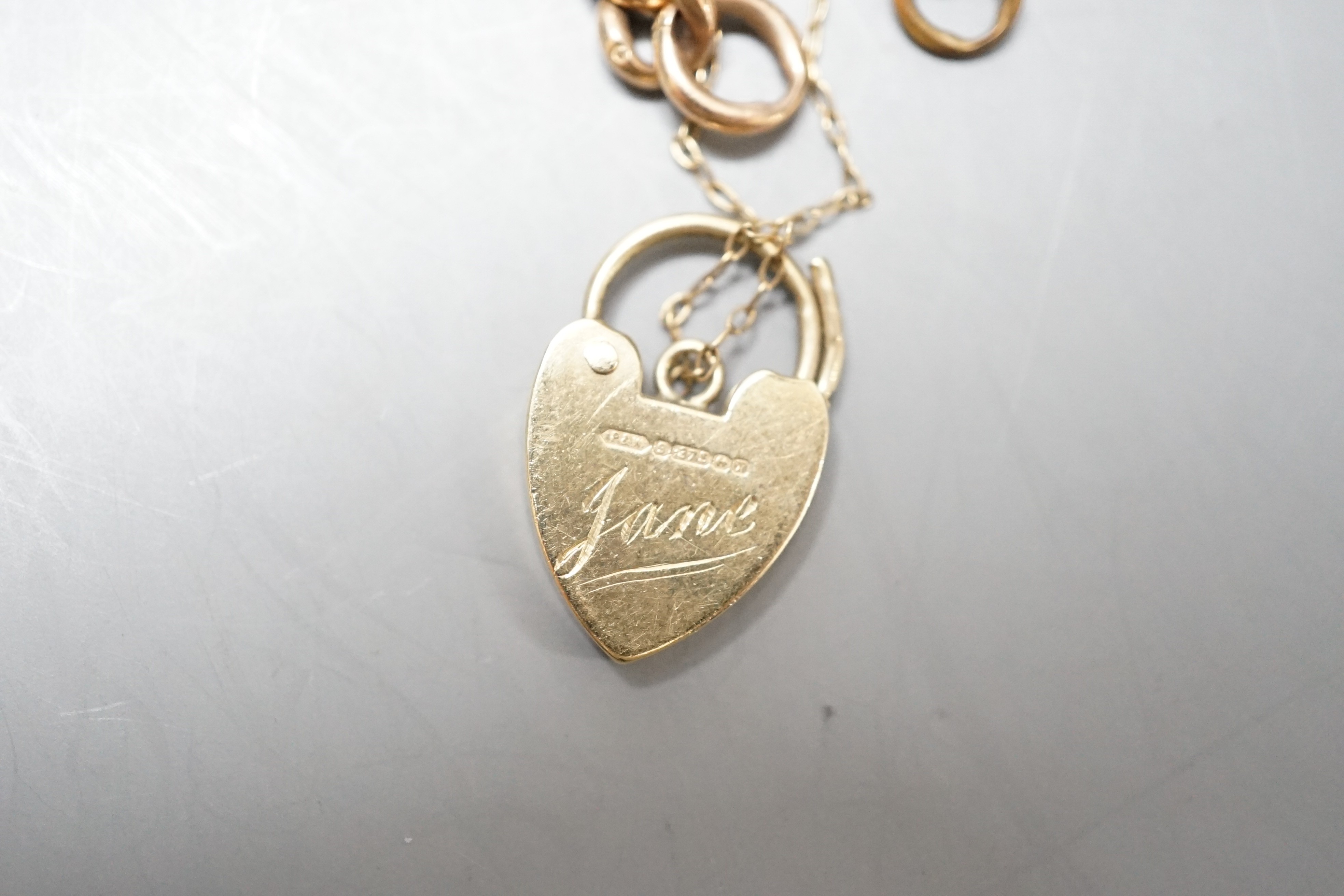 A 9ct gold curblink bracelet, with heart shaped padlock clasp, approx. 19cm
